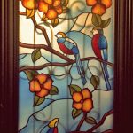 חלון צבעוני עם ציפורים פרחים ופרפרים